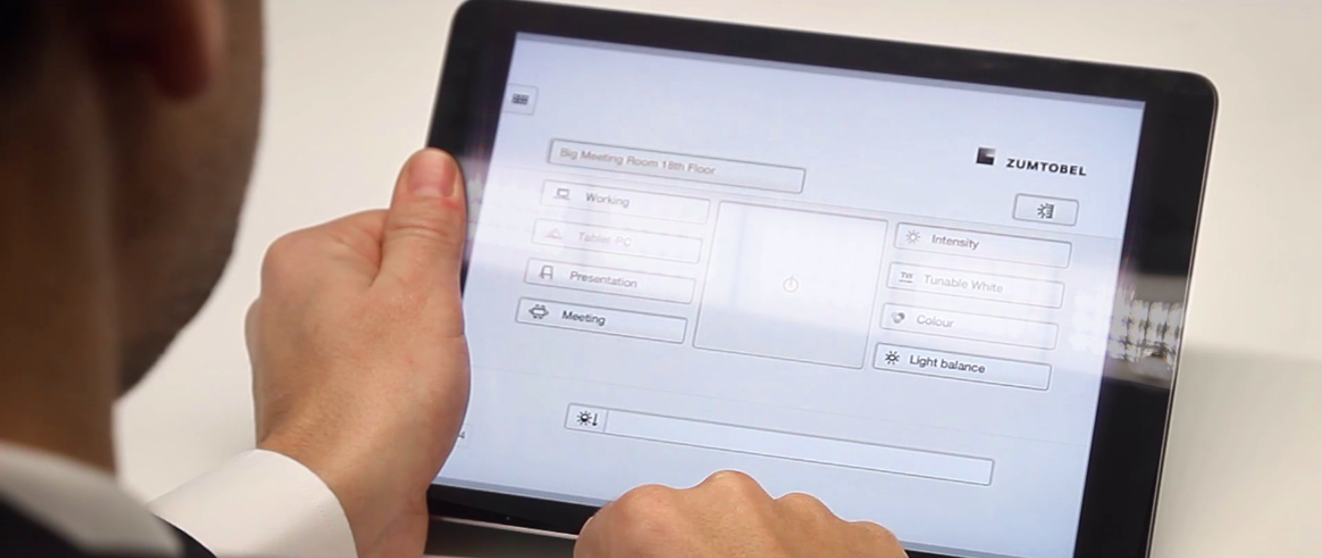Man holding a tablet watching a Zumtobel application.