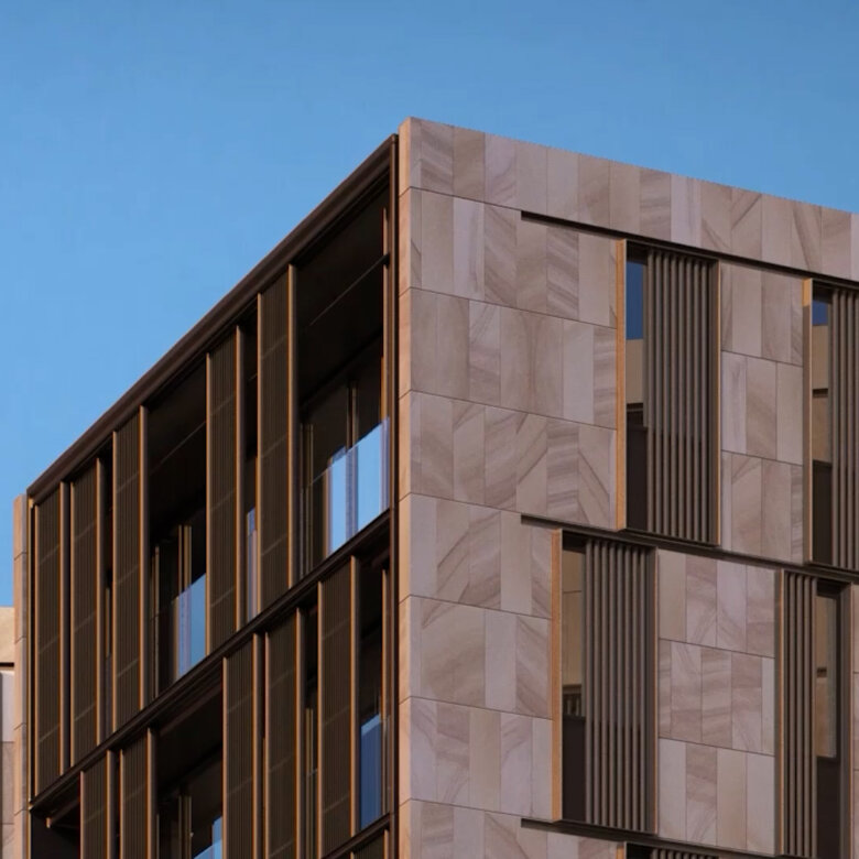 Part of a futuristic bulding in front of a blue sky, partly in sunlight.