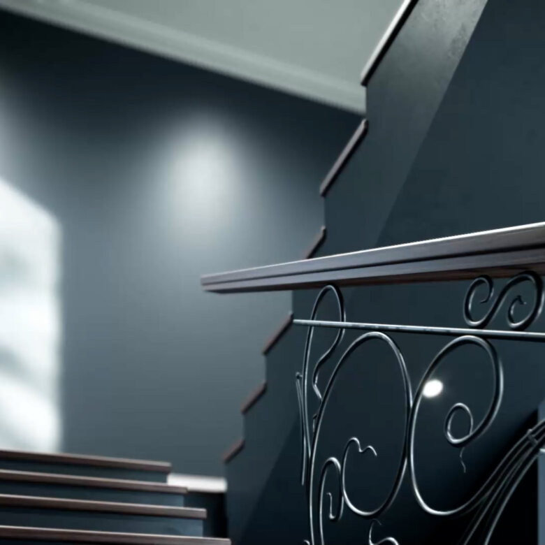 Staircase painted in dark grey with an old fashioned black railing. Sun shines through a window.