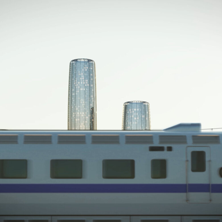 Train passing by in front of two exclusive round skyscrappers at dawn.