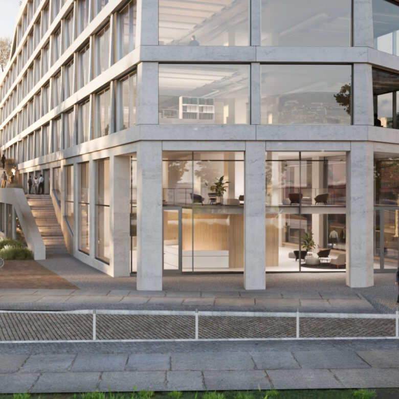 People in front of an office building with large glass windows in urban area with evening sun.