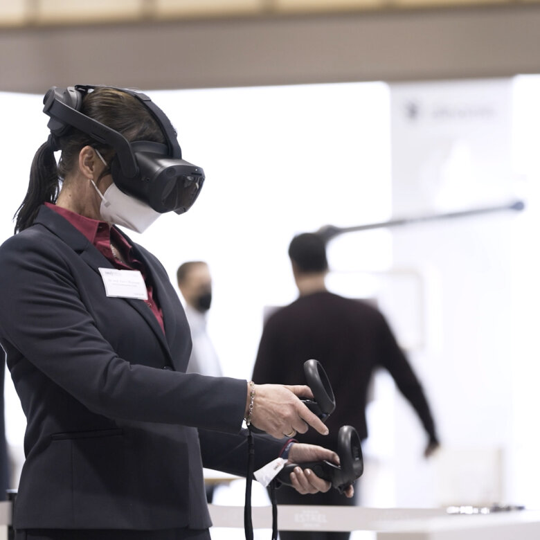 Woman wearing VR glasses holding joysticks.